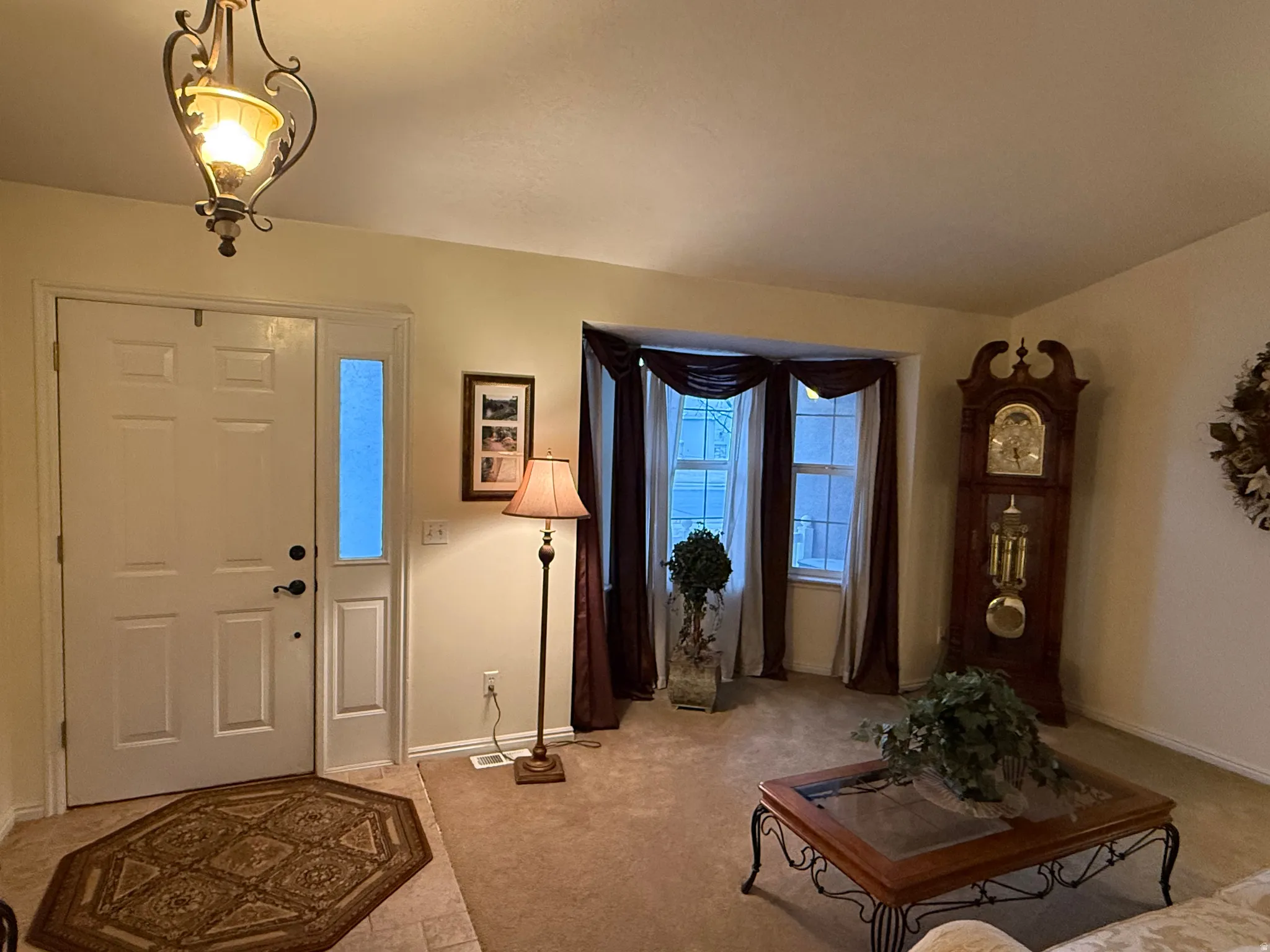 Entrance foyer featuring light colored carpet and baseboards