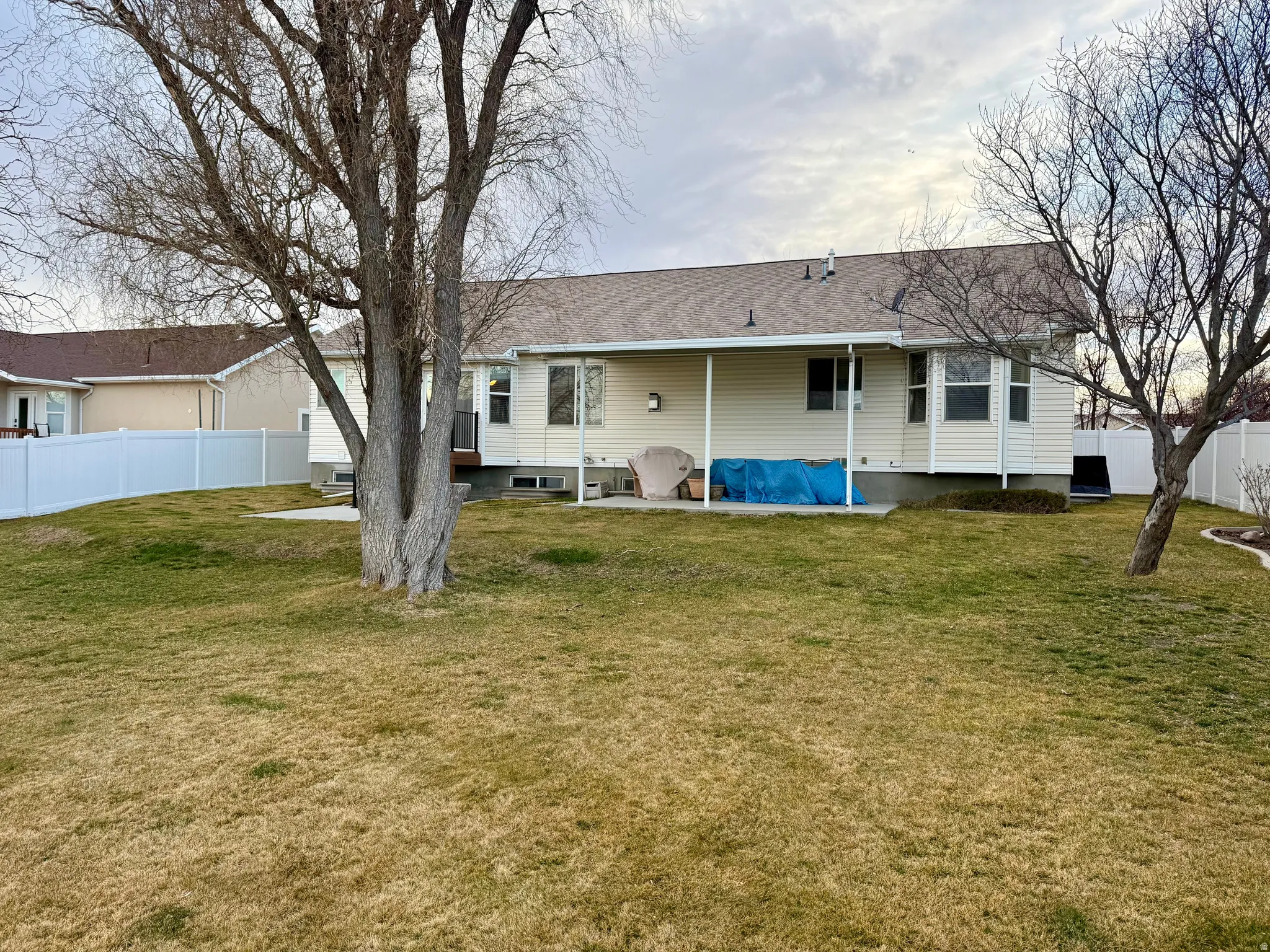 Back of house with a patio area and a shingled roof