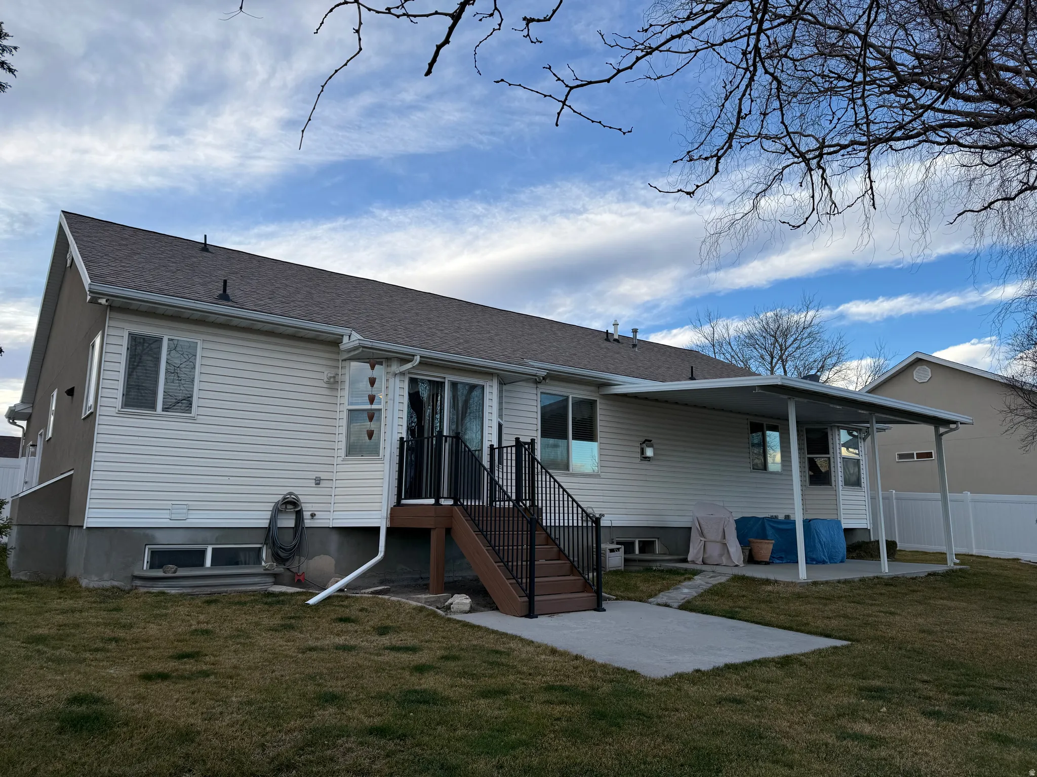 Rear view of property with a patio area and a shingled roof