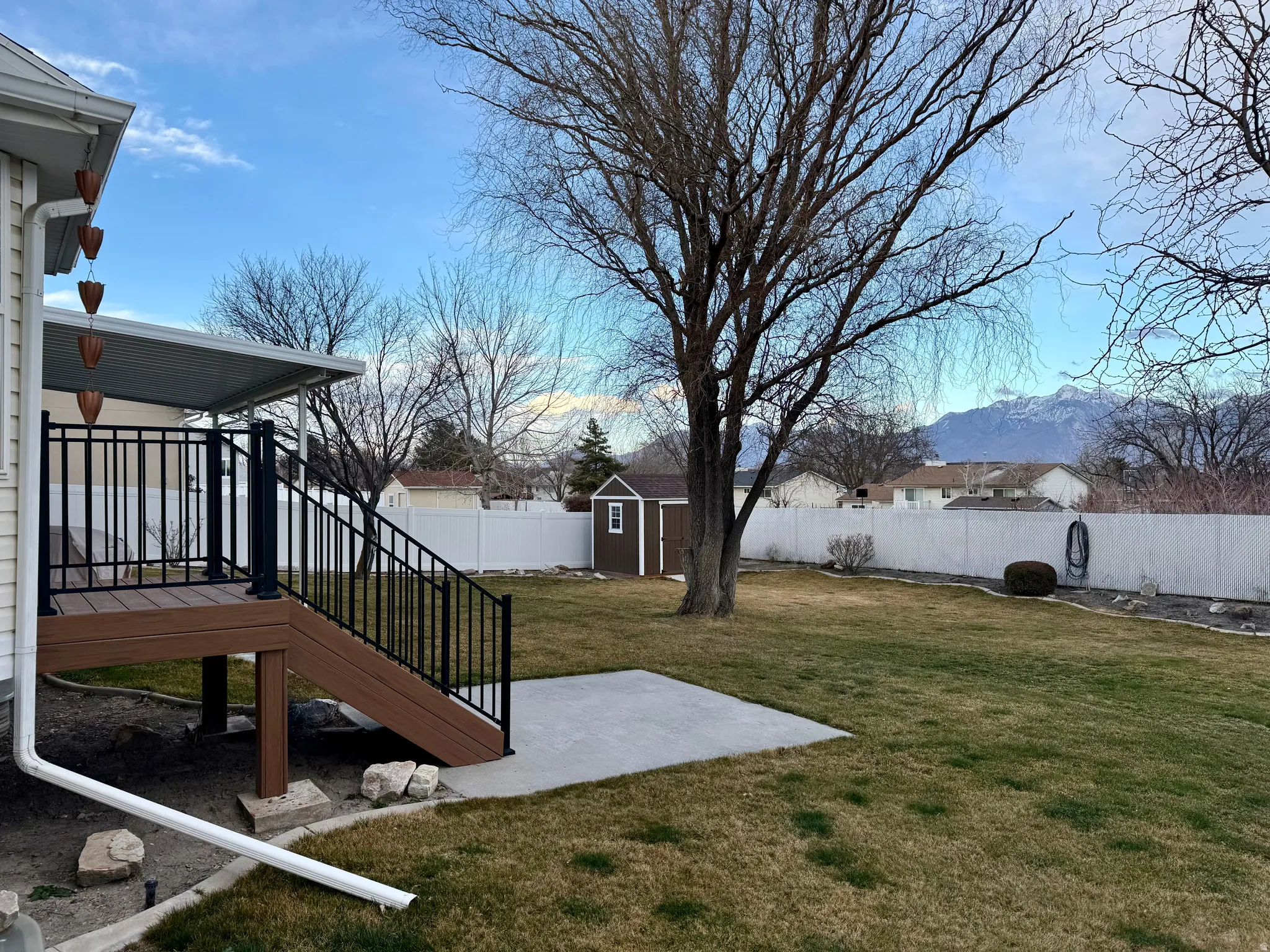 Fenced backyard featuring a patio area, a shed, and a mountain view