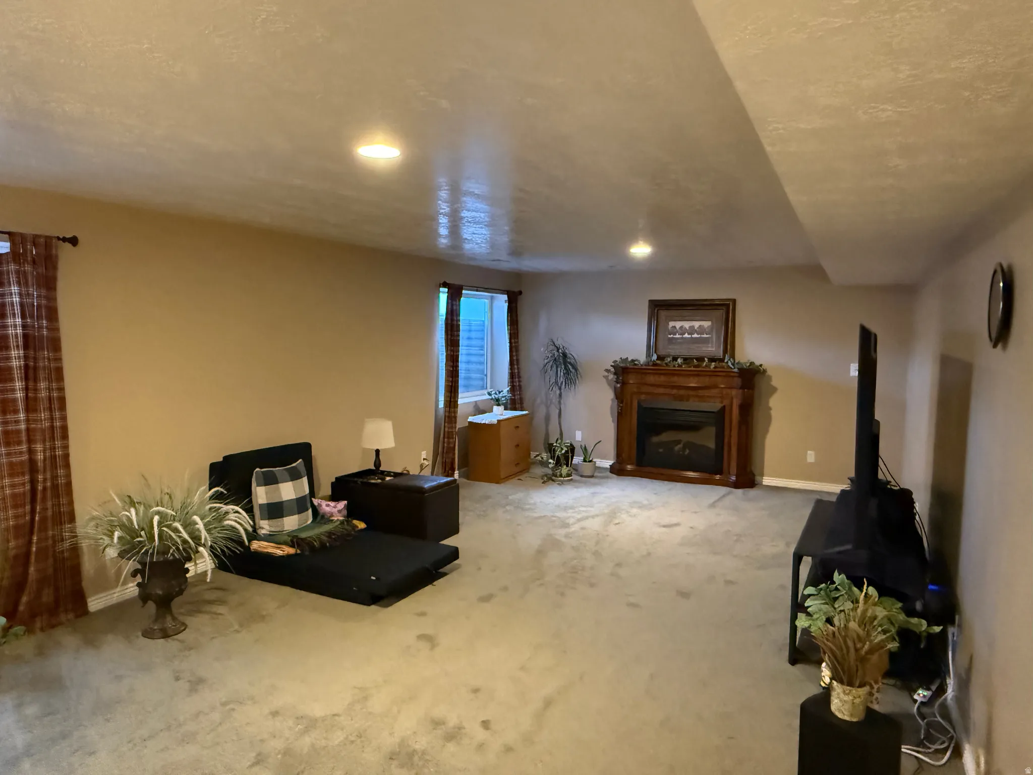 Living area with carpet flooring, a fireplace, and recessed lighting