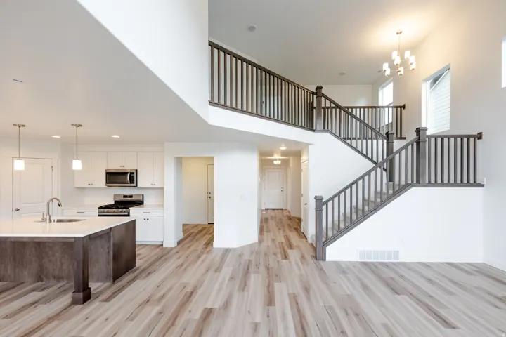 Open-concept living area featuring a prominent multi-level staircase with dark wood railings