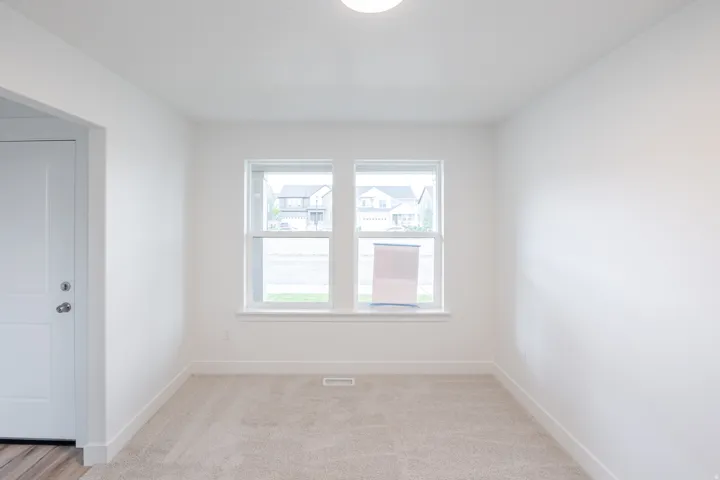 Bright interior space featuring two windows, neutral wall color, and carpet flooring