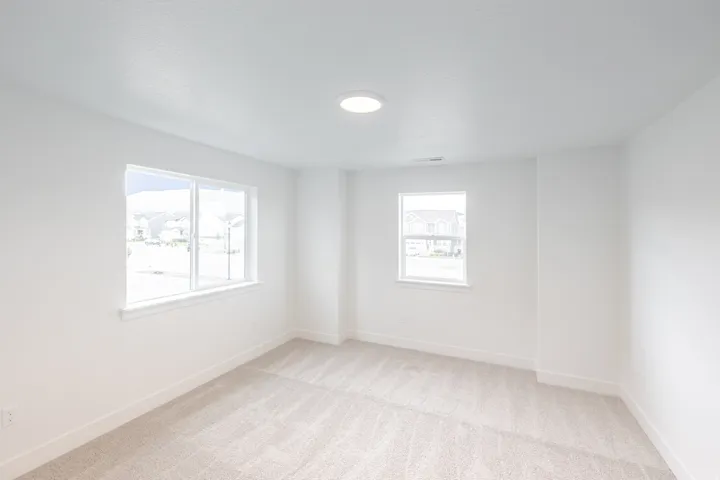 Neutral tone carpeting and white baseboards