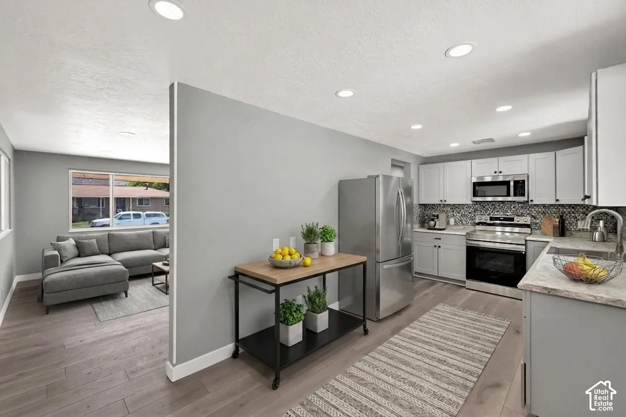 Modern kitchen featuring light gray cabinetry, and light-toned countertops. Virtually staged to illustrate the home's potential.