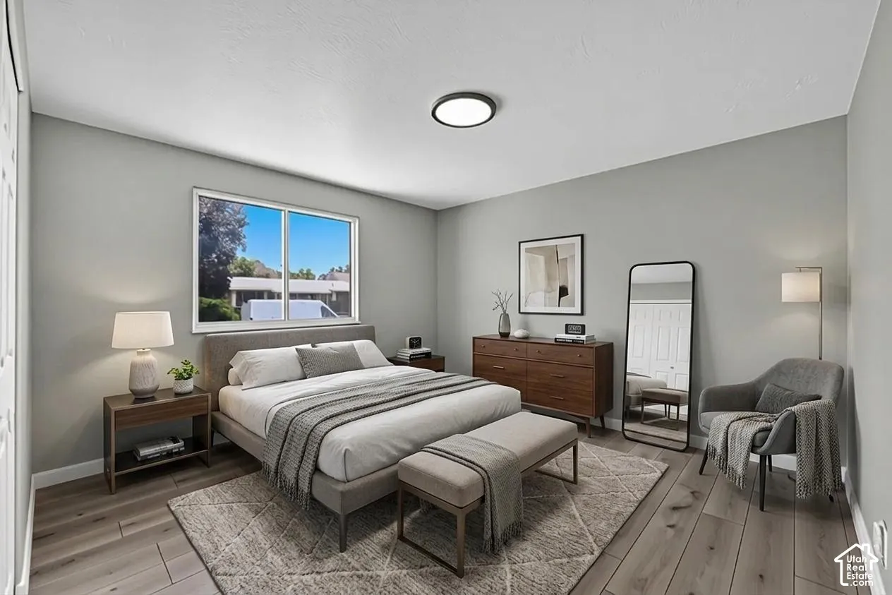 Wood-finish flooring, recessed ceiling lighting, a large window, and light gray wall tones