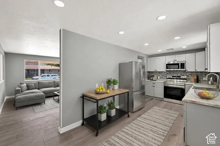 Modern kitchen featuring light gray cabinetry, and light-toned countertops. Virtually staged to illustrate the home's potential.
