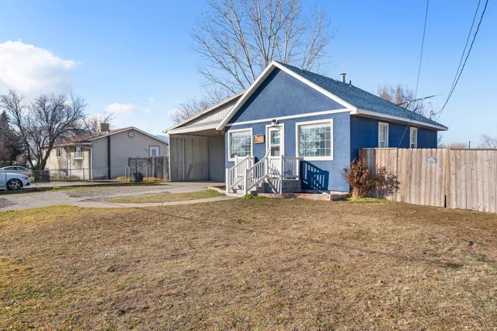 Bungalow-style house with stucco siding, an attached carport, concrete driveway, and roof with shingles