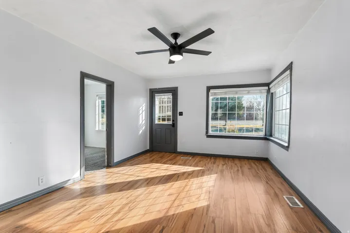 Entrance foyer with light wood-style floors, ceiling fan, and plenty of natural light