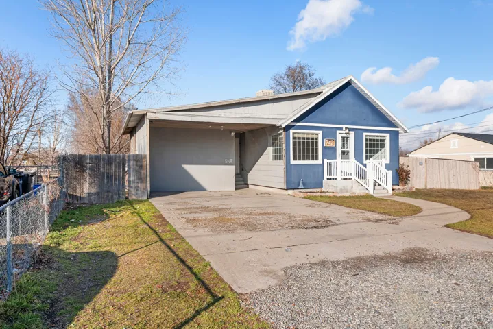 View of front of house featuring concrete driveway and a carport