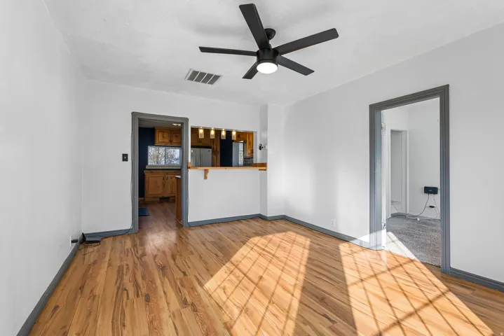 Unfurnished living room with wood finished floors and ceiling fan