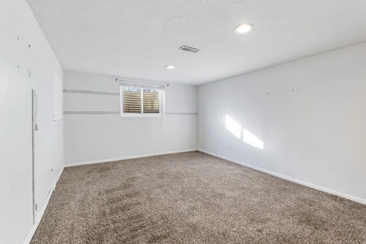 Spare room featuring carpet and baseboards