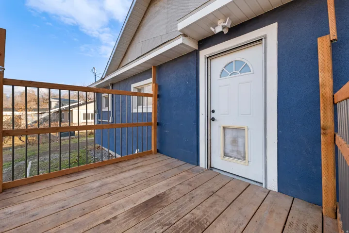 Entrance to property with stucco siding and a deck