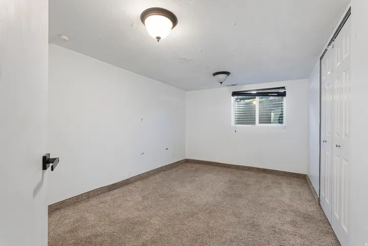 Unfurnished bedroom featuring carpet flooring, a closet, and a textured ceiling