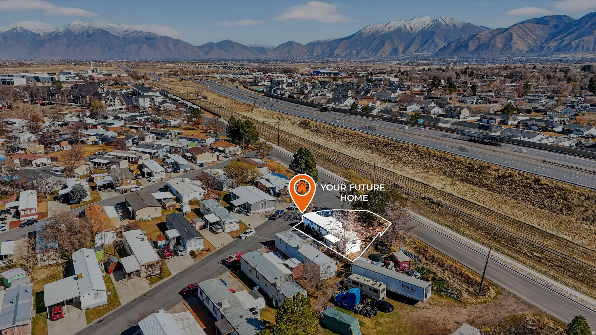 Aerial perspective of suburban area featuring a mountainous background and property parcel outlined