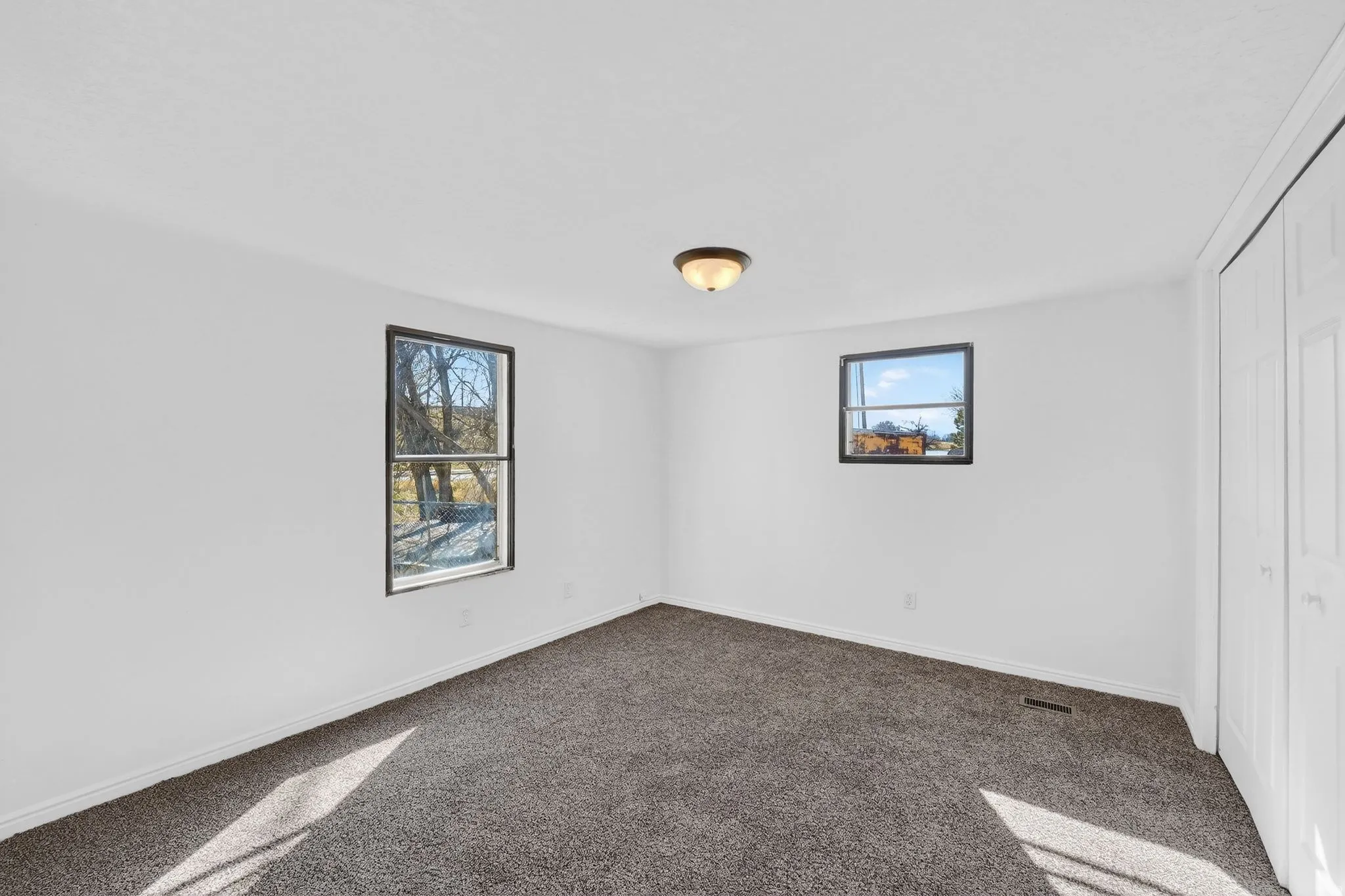 Unfurnished bedroom with dark carpet and a closet