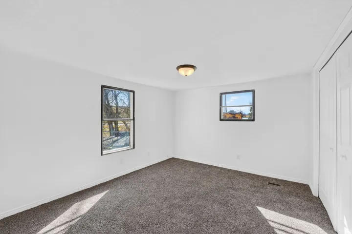 Unfurnished bedroom with dark carpet and a closet