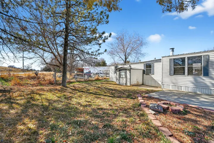 View of yard with a storage unit and a patio