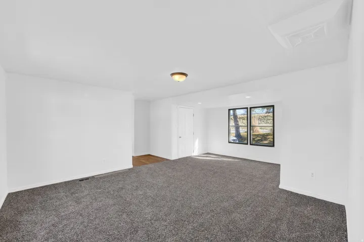 Carpeted empty room with baseboards