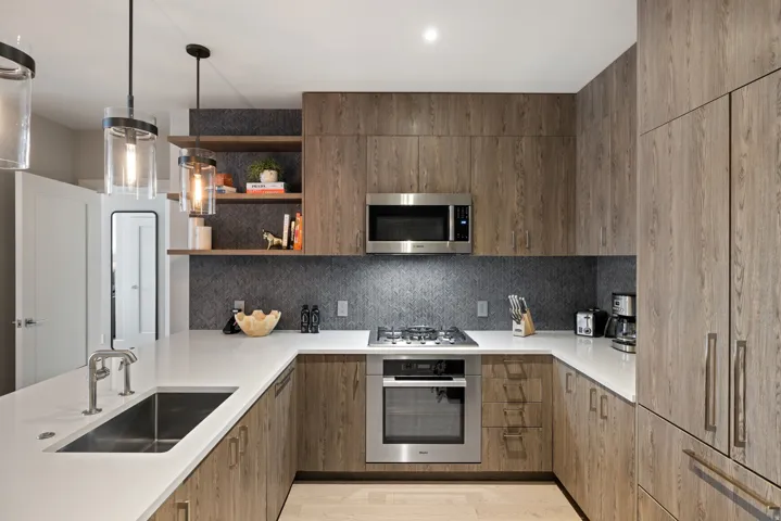 Kitchen featuring stainless steel appliances, hanging light fixtures, open shelves, modern cabinets, and backsplash