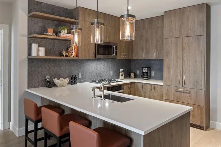 Kitchen with modern cabinets, light wood-type flooring, open shelves, and a breakfast bar area