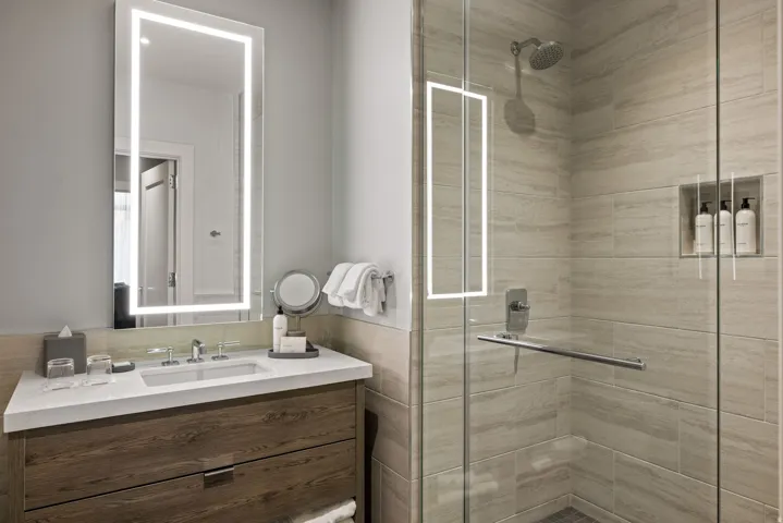 Bathroom with vanity, a shower stall, tile walls, and wainscoting