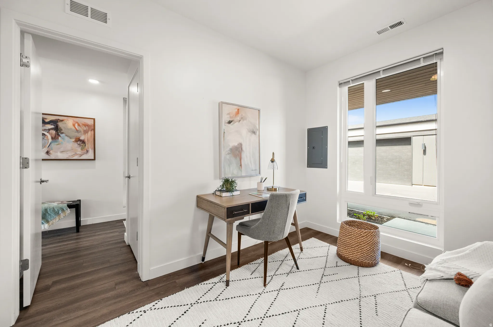 Office with wood finished floors and electric panel