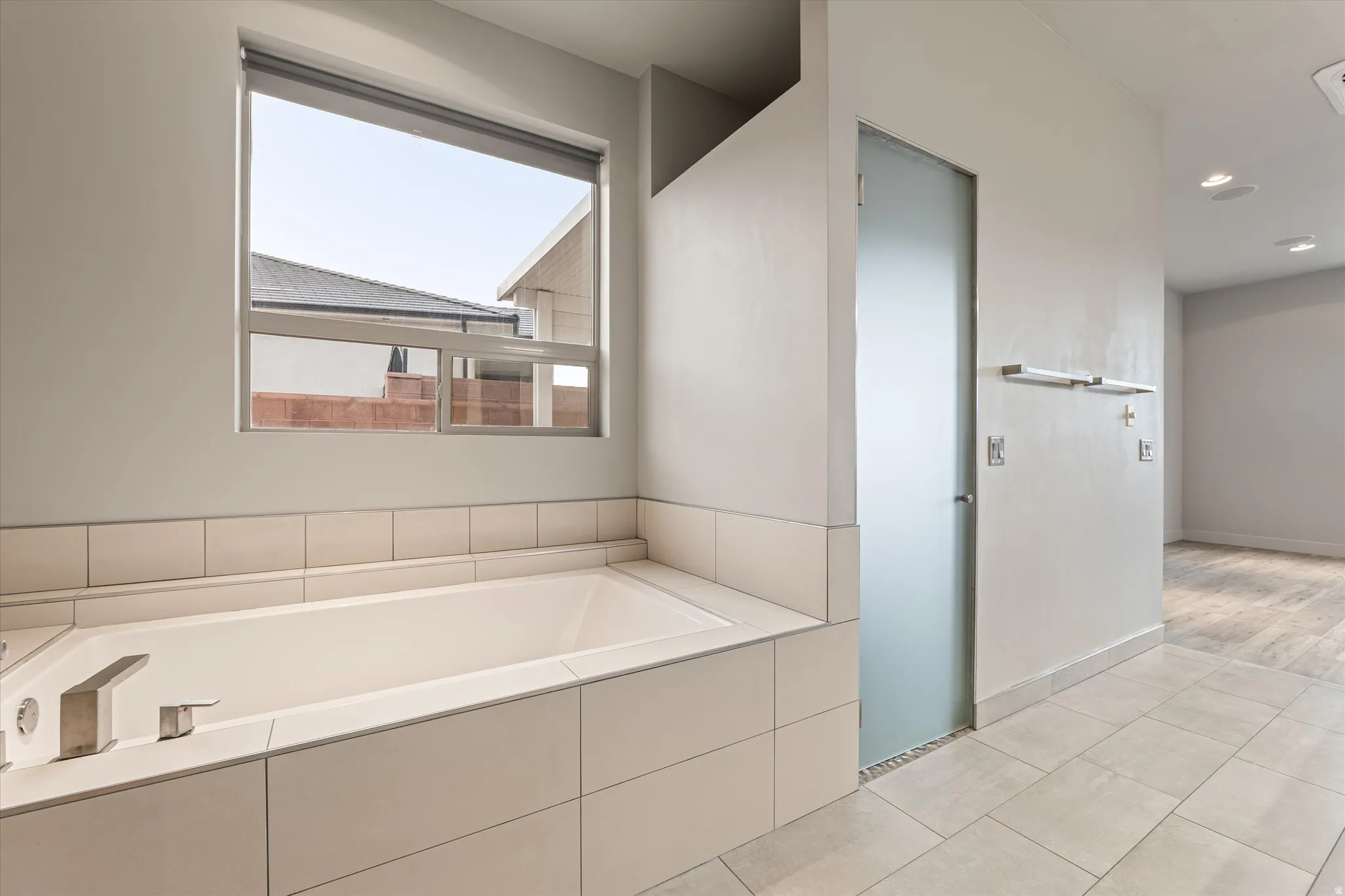 Full bathroom with light tile patterned flooring, a bath, and a skylight