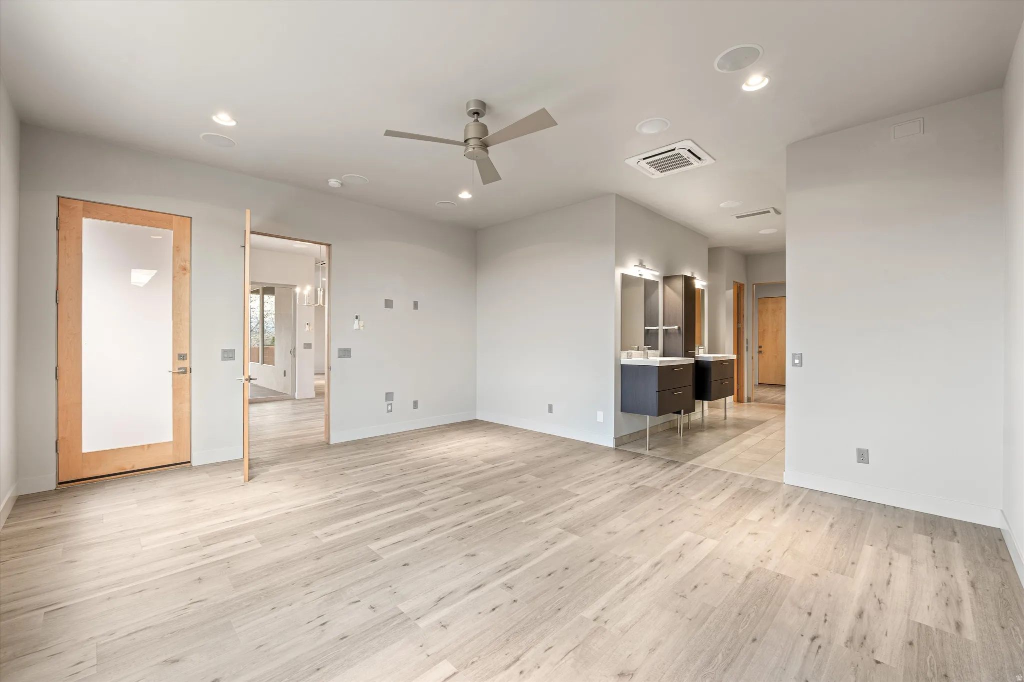 Unfurnished living room featuring ceiling fan, light wood-type flooring, recessed lighting, and cooling unit