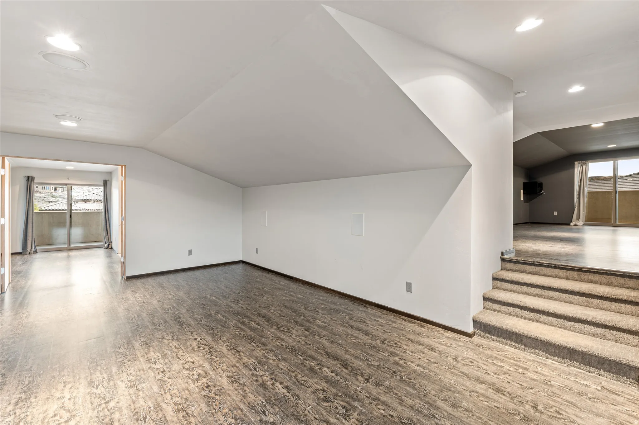 Additional living space with lofted ceiling, recessed lighting, and wood finished floors