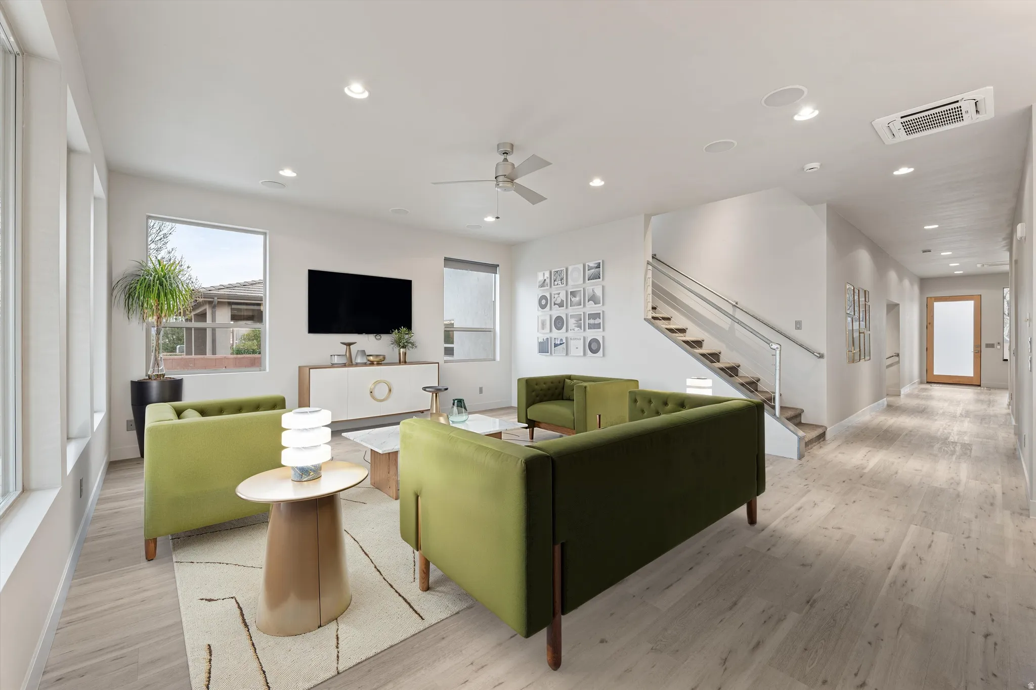 Living room with wood finished floors, a ceiling fan, recessed lighting, and cooling unit