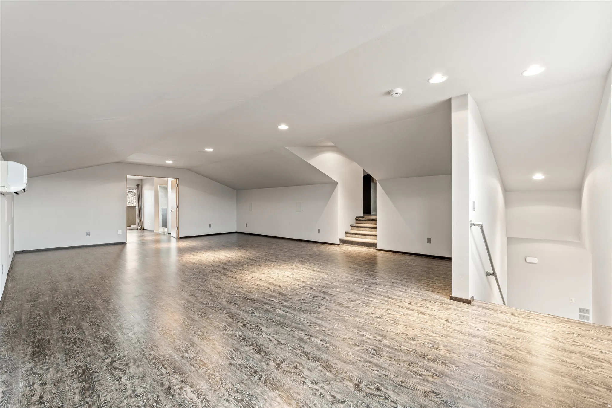 Additional living space featuring wood finished floors, vaulted ceiling, and recessed lighting