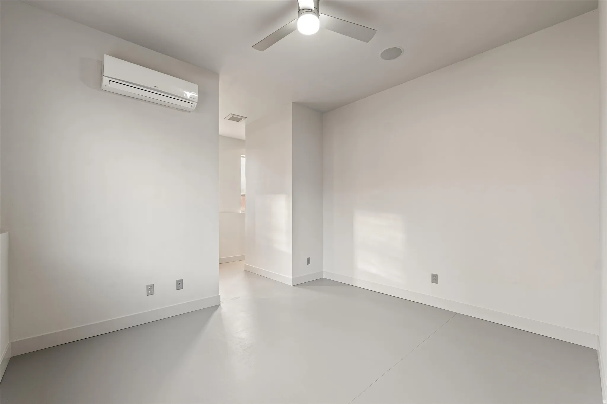 Empty room with concrete floors and ceiling fan