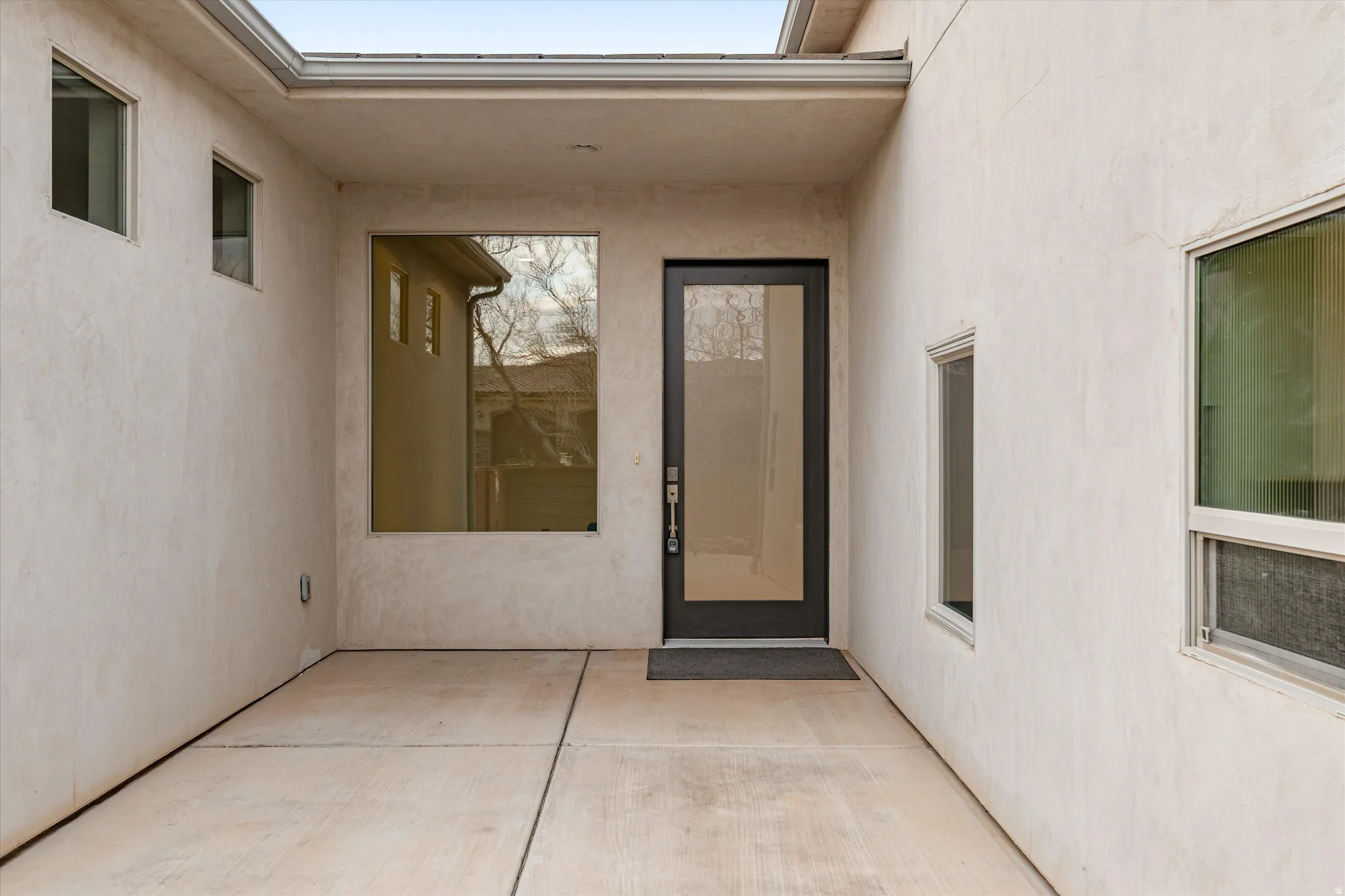Property entrance with stucco siding and a patio
