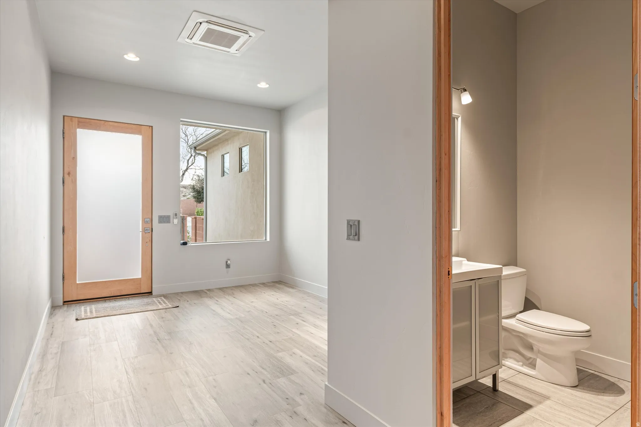 Entryway with cooling unit, light wood-style floors, and recessed lighting