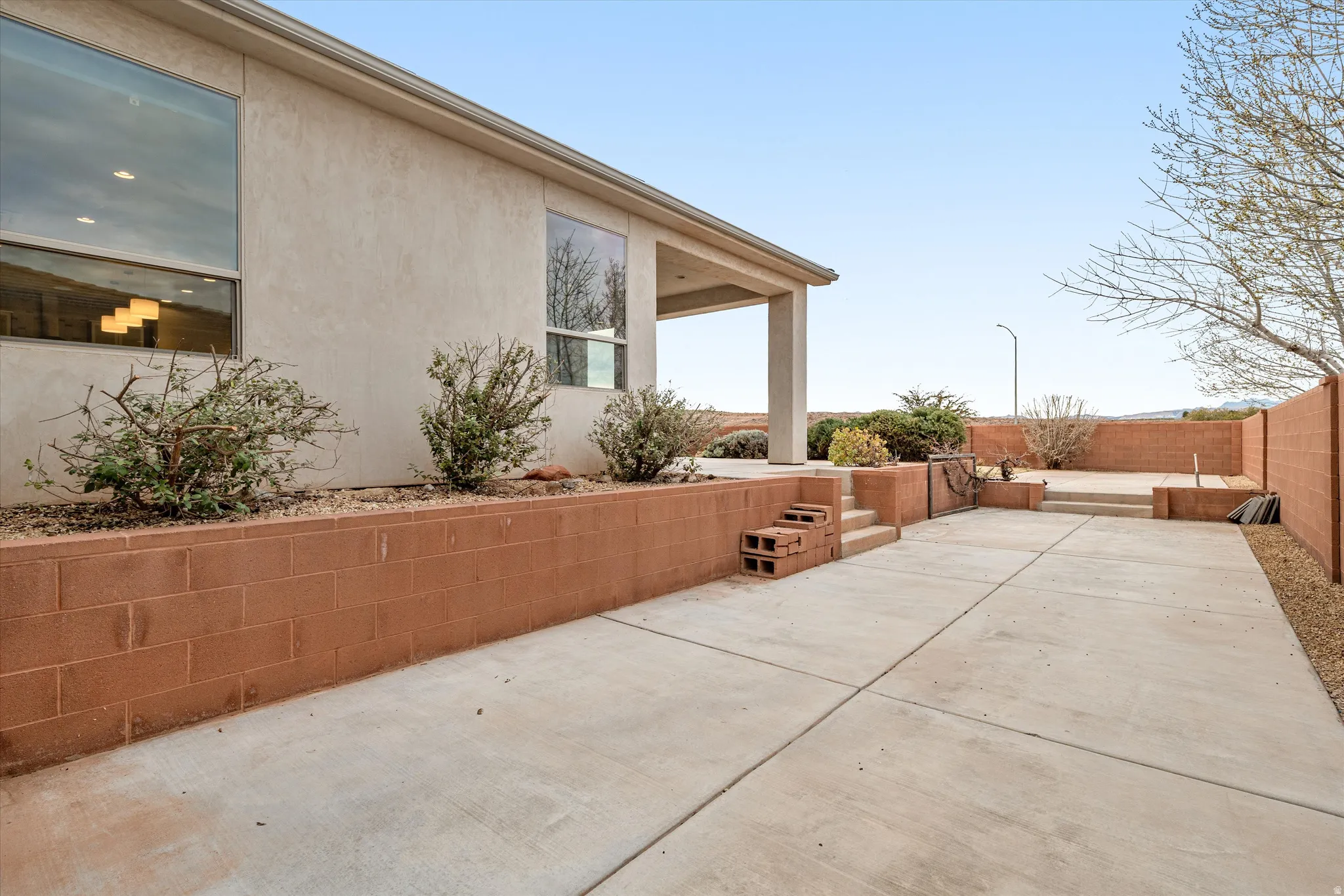 View of side of property with a patio area, stucco siding, and a fenced backyard