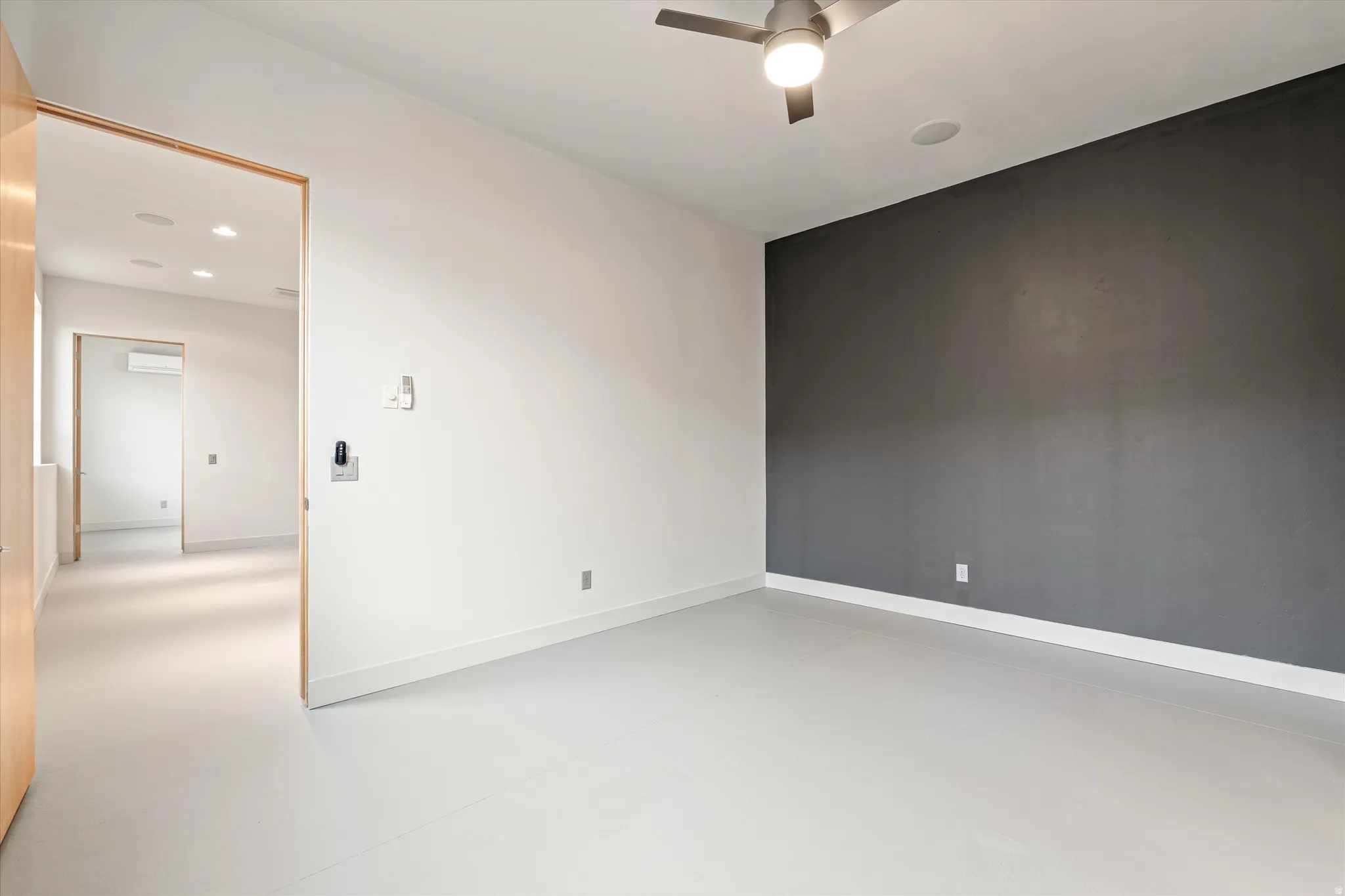 Empty room with finished concrete floors, ceiling fan, and recessed lighting