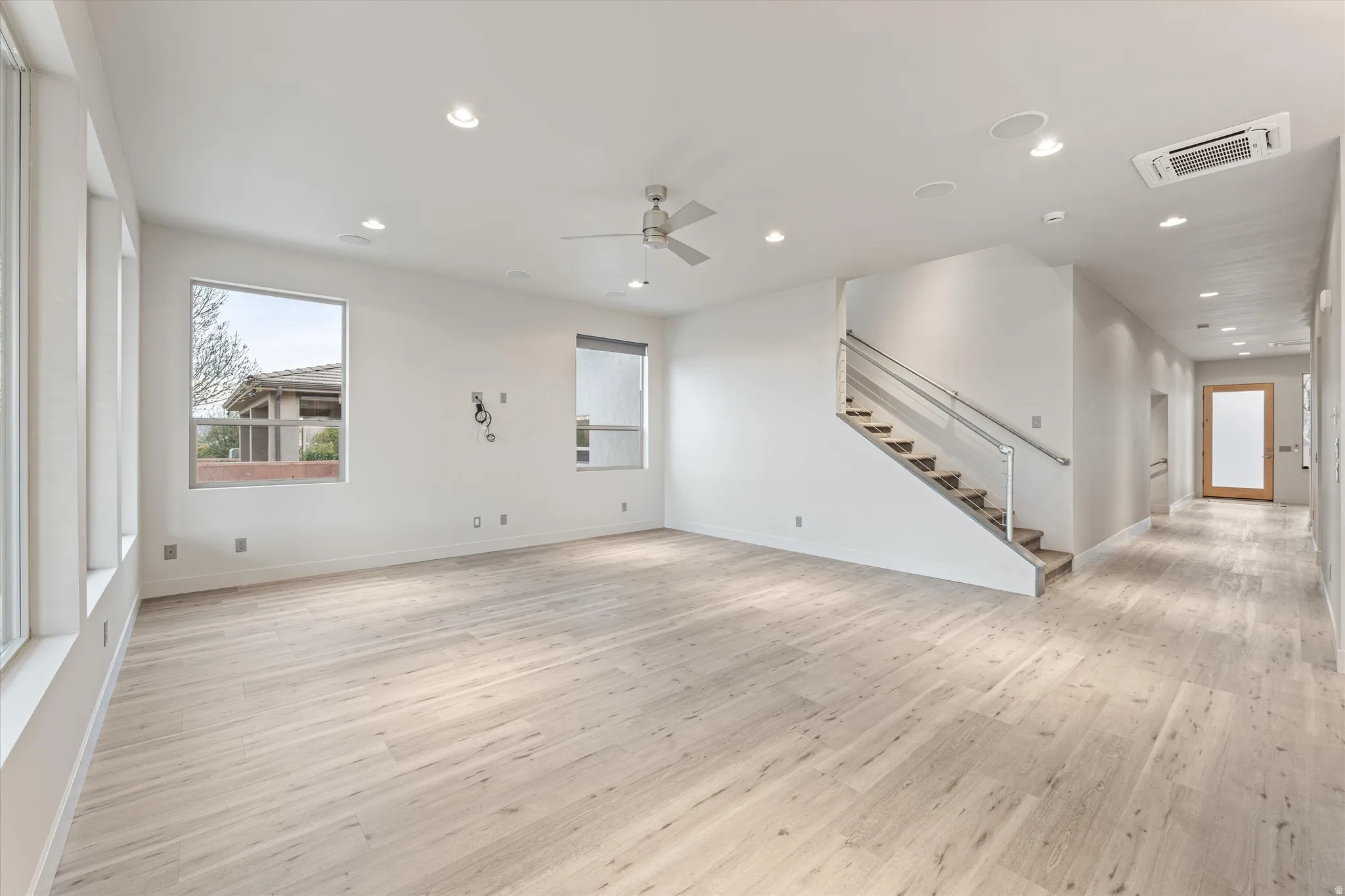 Unfurnished living room with light wood finished floors, a ceiling fan, recessed lighting, and cooling unit