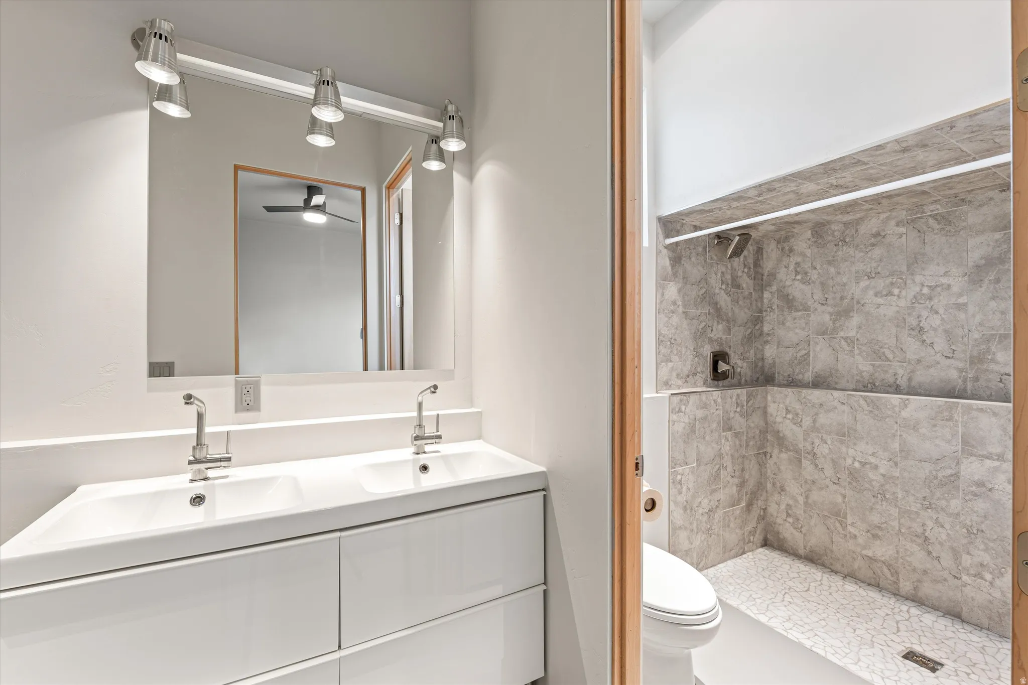 Full bathroom with double vanity and a stall shower