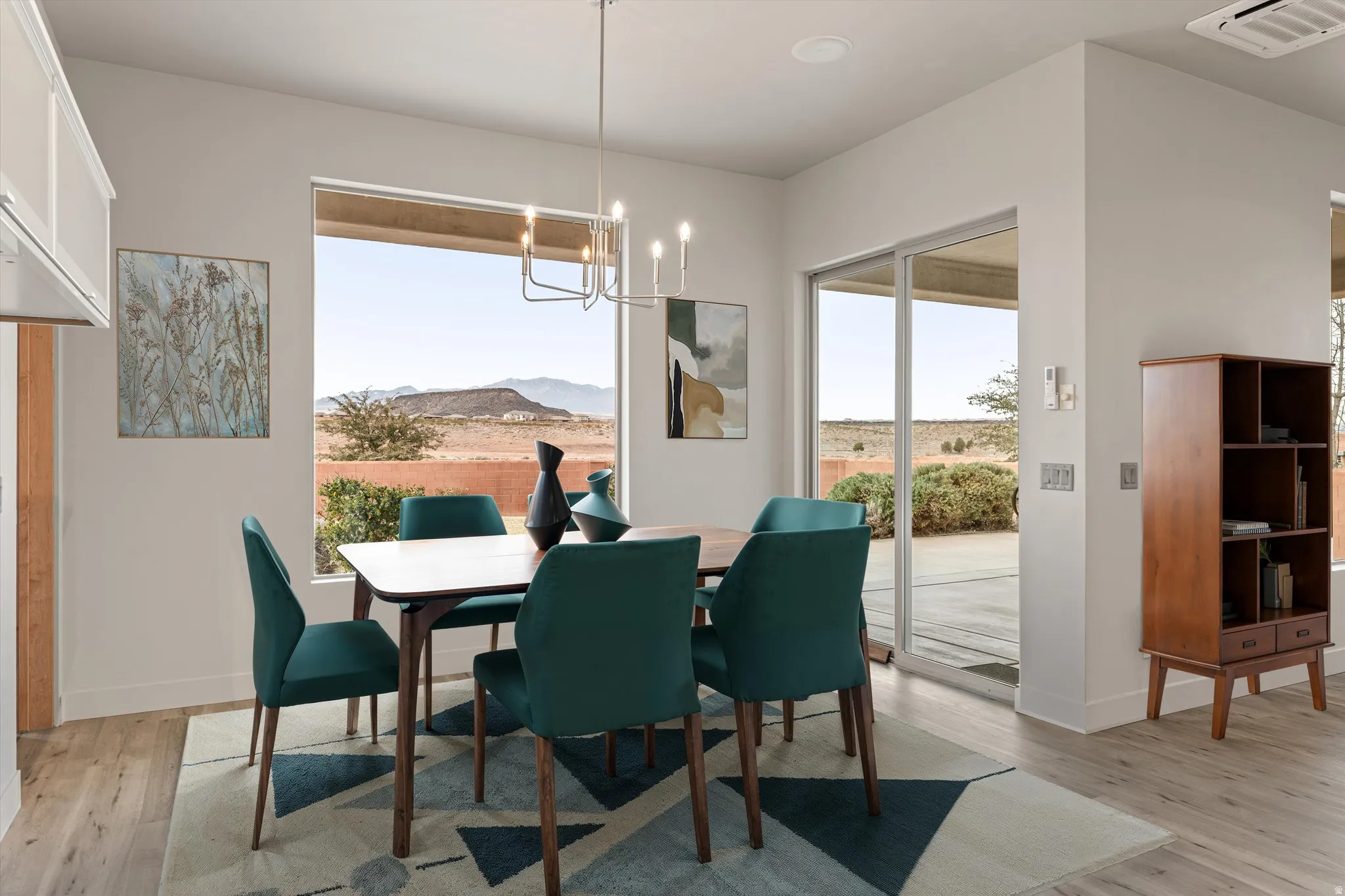 Dining room with a mountain view, light wood-style flooring, and hanging lights