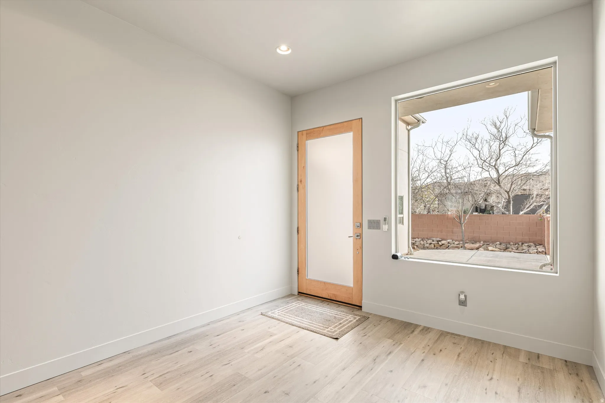 Doorway featuring wood finished floors and recessed lighting
