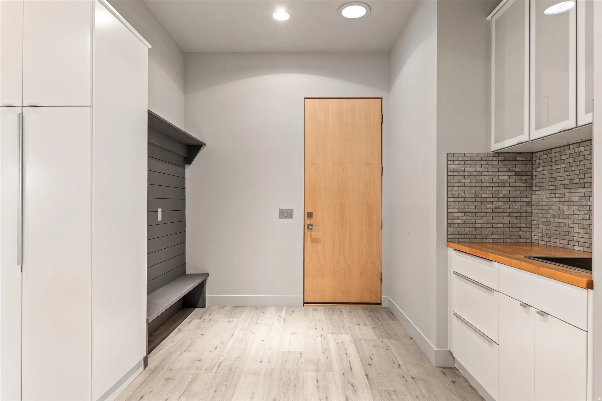 Mudroom with light wood finished floors and recessed lighting