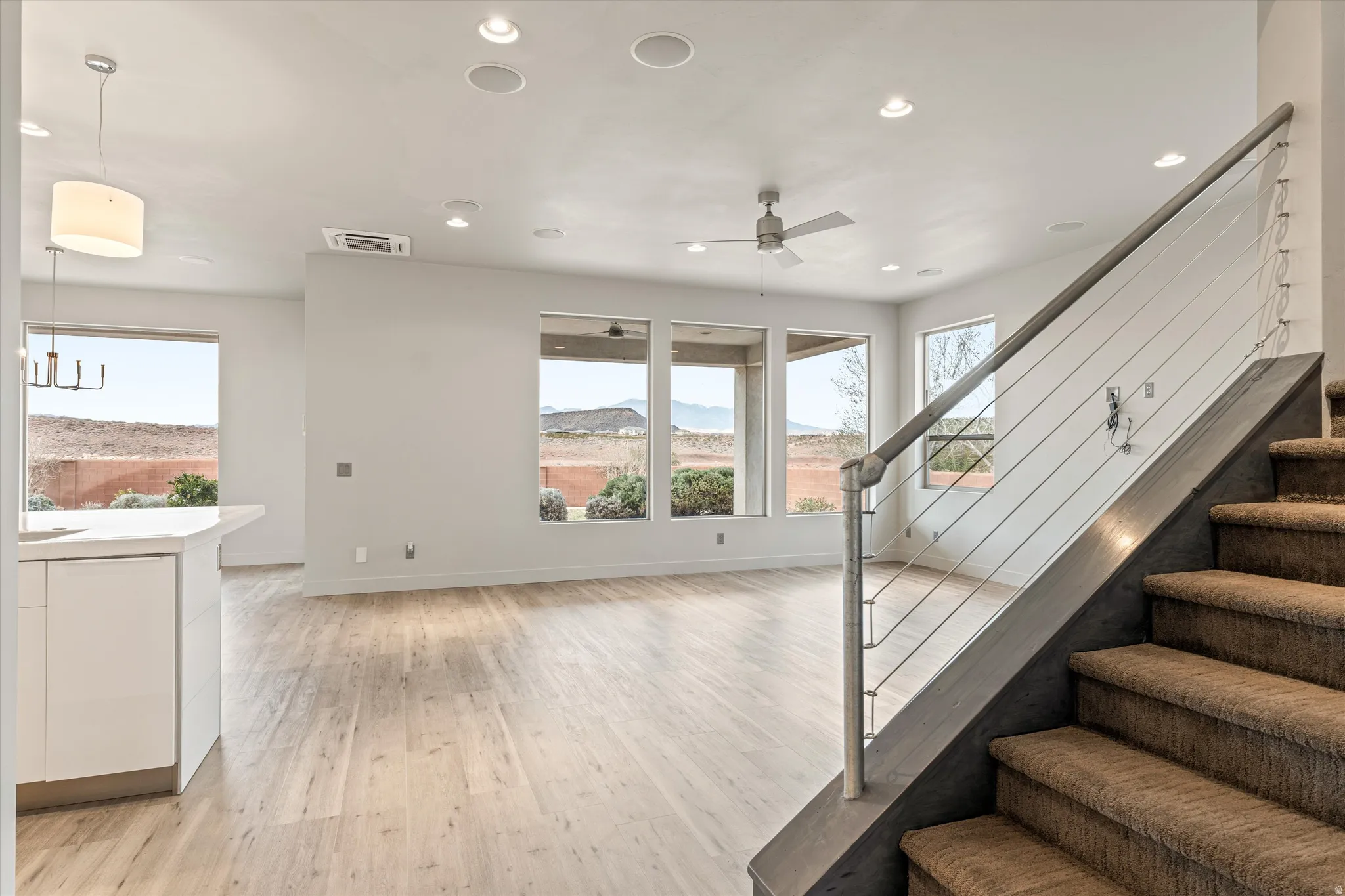 Stairs featuring wood finished floors, a mountain view, recessed lighting, and ceiling fan