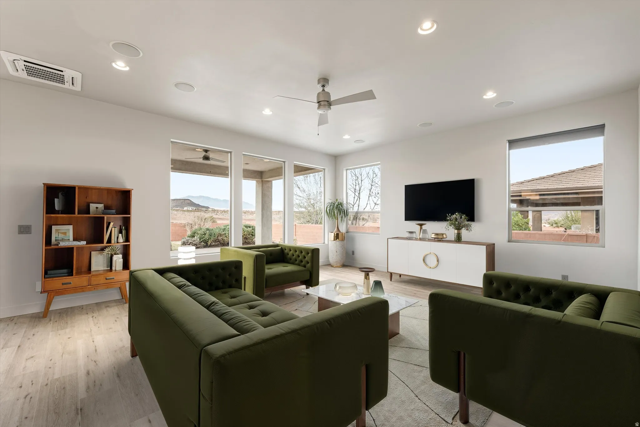 Living area featuring light wood-style floors, plenty of natural light, cooling unit, recessed lighting, and ceiling fan