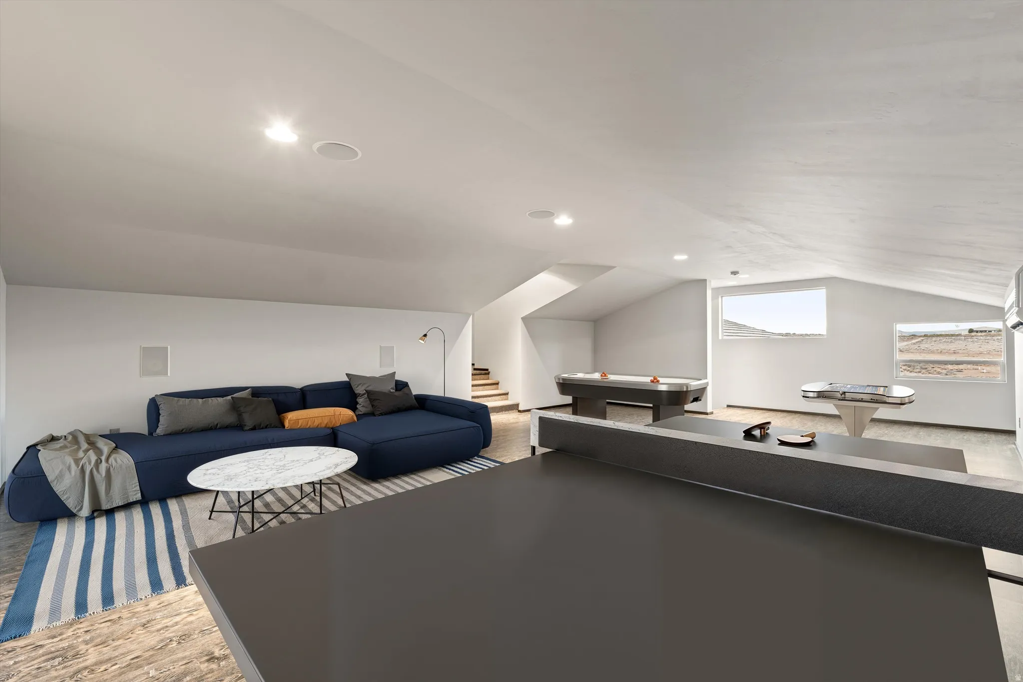 Recreation room with vaulted ceiling, light wood finished floors, and recessed lighting