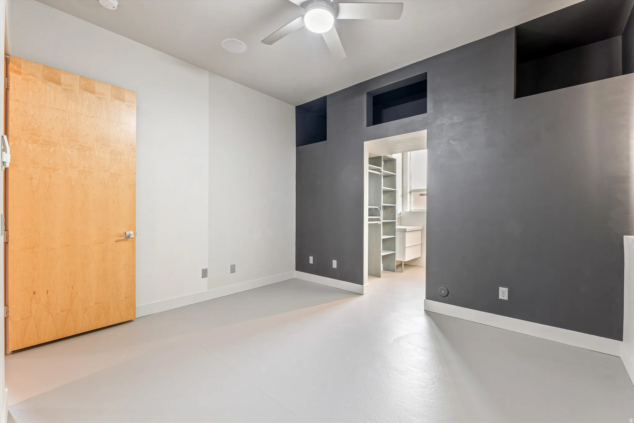 Spare room with finished concrete floors and ceiling fan