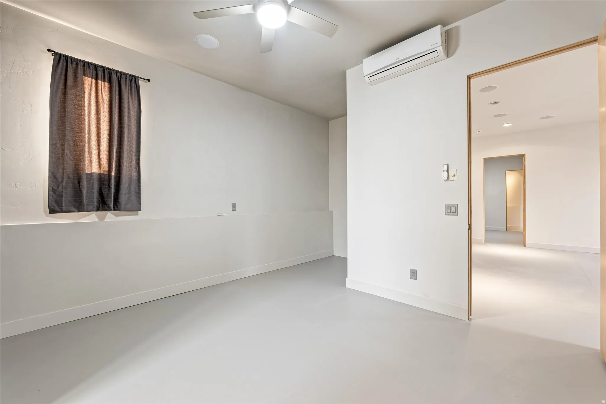 Unfurnished room featuring concrete flooring and ceiling fan