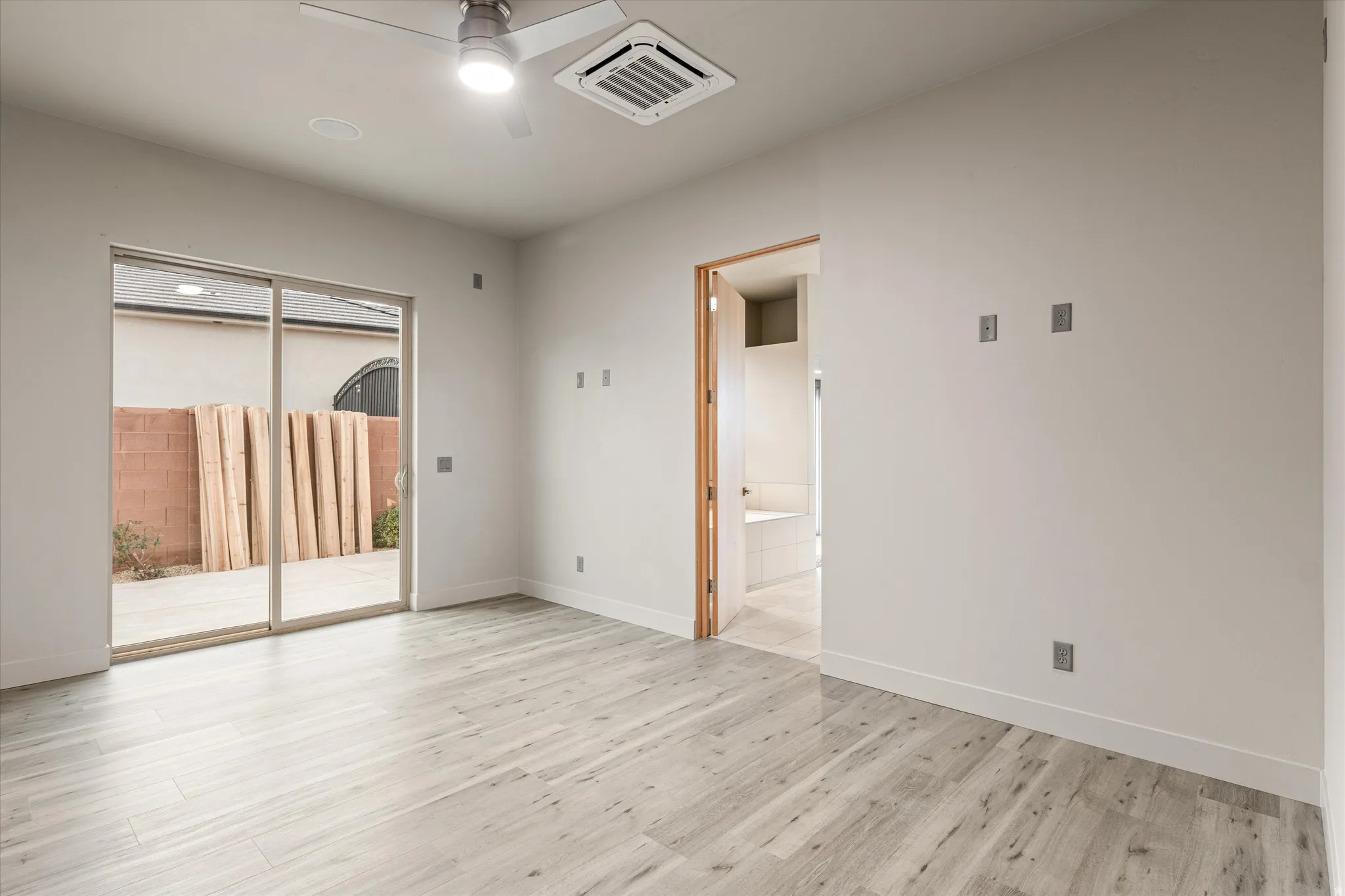 Empty room with cooling unit, ceiling fan, and light wood-type flooring