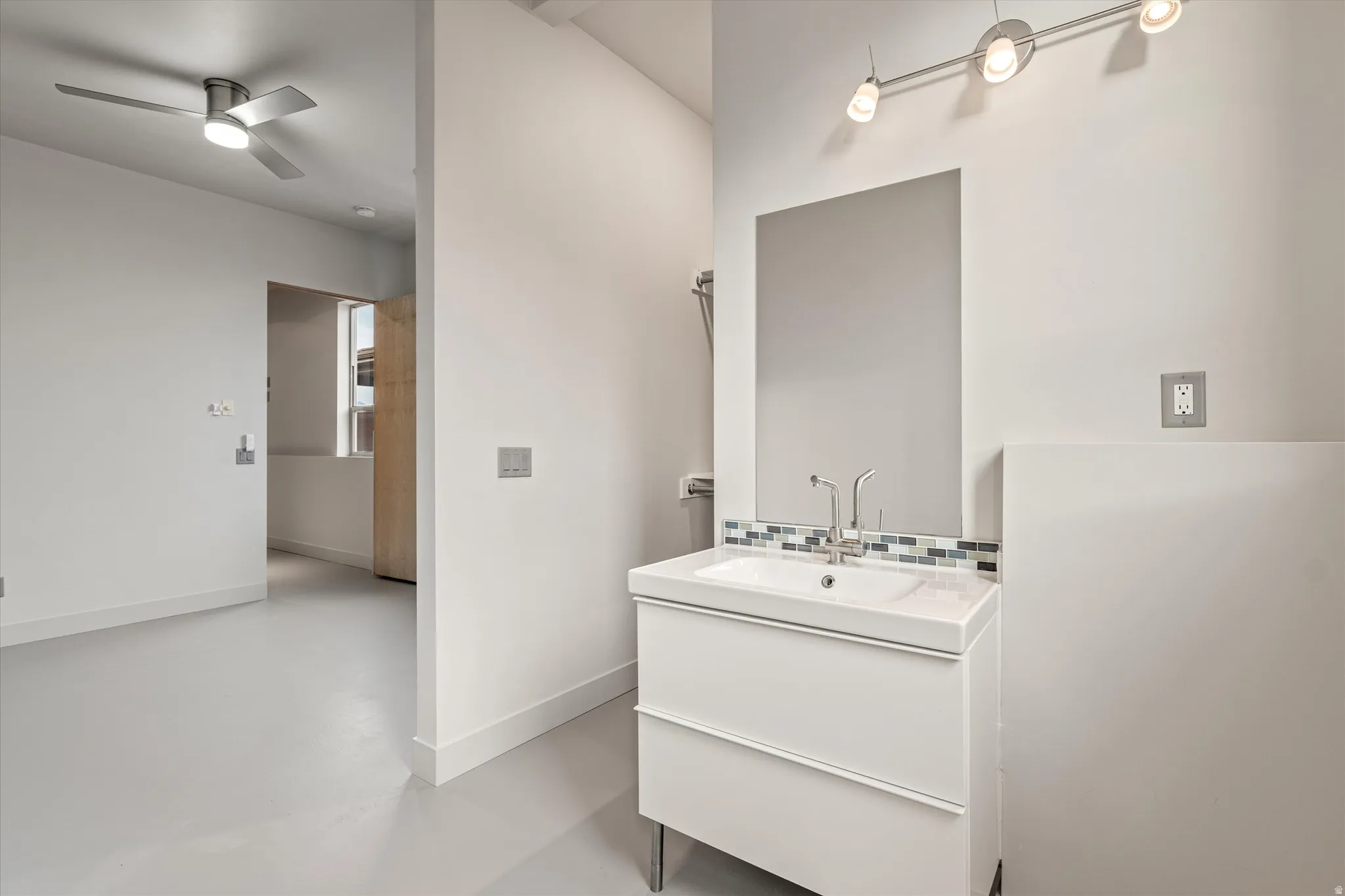 Half bath with vanity, finished concrete floors, and ceiling fan