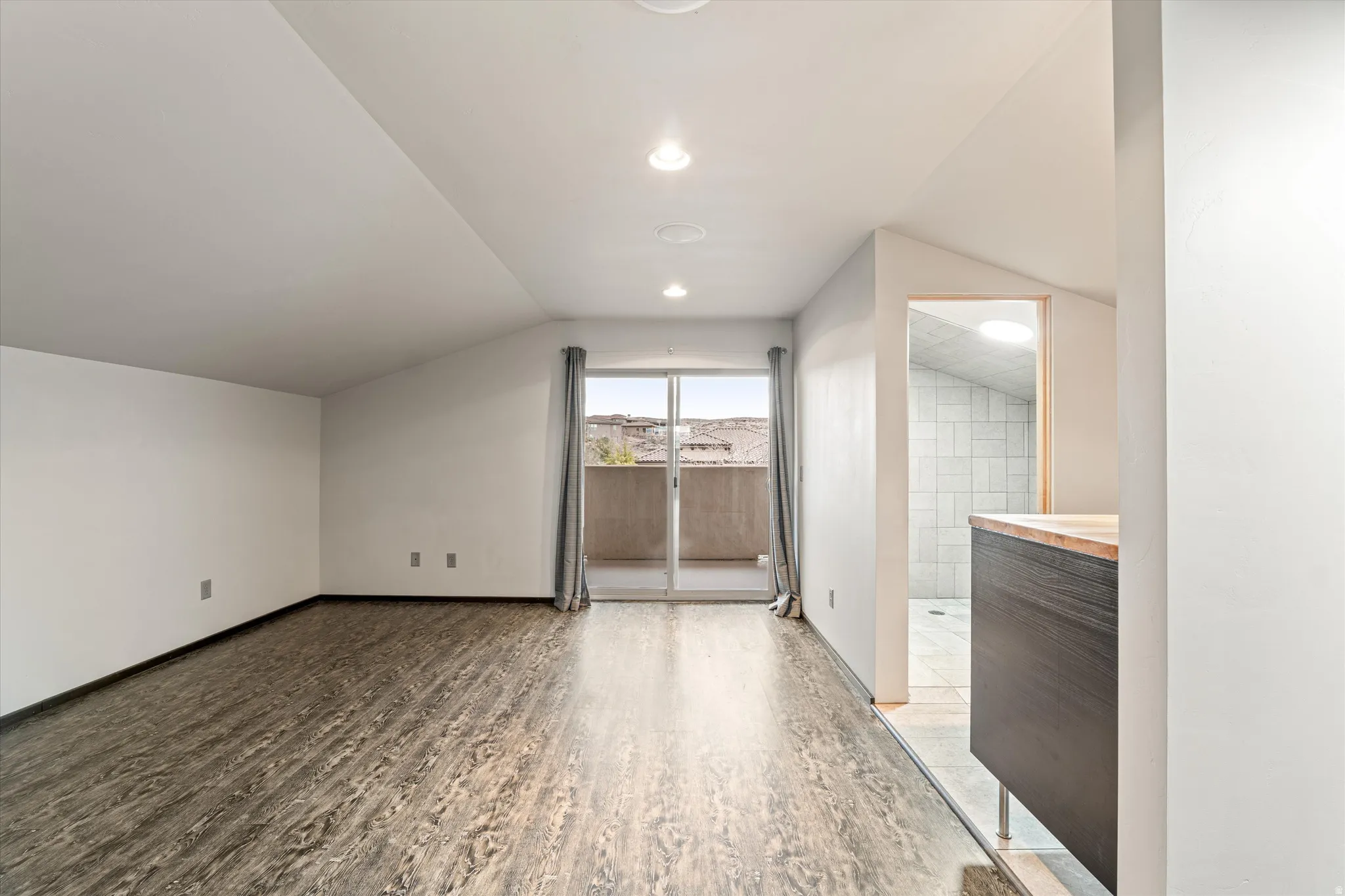 Additional living space featuring light wood finished floors, lofted ceiling, and recessed lighting